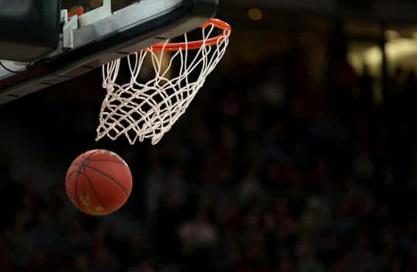 Ballon de basket entrant dans le panier sous les projecteurs