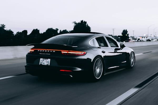 Voiture de sport noire roulant à vive allure sur une route